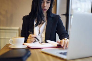Uzman çözümlenirken bilgi dizüstü kullanarak yaratıcı proje üzerinde durulması konsantre kadın girişimci para işlem kafe, çalışma online bankacılık hizmet kullanarak profesyonel yapım pazarlama