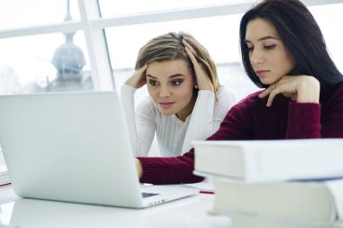 Webinar dizüstü bilgisayar cihaza kablosuz yüksek hızlı 4 g için bağlanma arkadaşı ile birlikte izlerken yorgun sarışın öğrenci internet. Genç kadın modern teknoloji üniversitede öğrenim konsantre