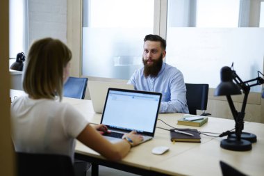 Kadın profesyonel programcı sahte kablosuz internet'e bağlı ve meslektaşım Office Başlangıç projesi için fikirler tartışırken ekranı ile modern dizüstü bilgisayar hakkında bilgi Tarama görünümünü geri