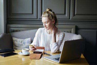 Güzel durulması yetenekli öğrenci 4 g kahve sırasında Internet kırmak kafeteryada bağlı Smartphone uygulama kullanarak sosyal ağlarda arkadaşlarınızla mesajlaşma beyaz kazak giymiş