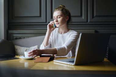 Şef smartphone ve dikkatli bir şekilde kapalı otururken dinleme yoluyla çekici kadın iletişim durulması. Sevimli Genç Sarışın kadın rahat yerine kahve molası sırasında cep telefonunuzun söz