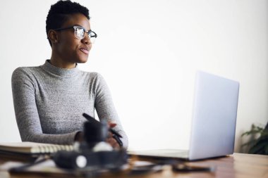 Çekici afro Amerikan kadın fotoğrafçı serbest planlama yaratıcı proje promosyon arka plan, müreffeh işkadını başlangıç hakkında düşünme üzerinde oturan multimedya dosyaları ile çalışma