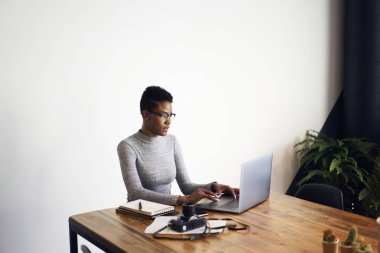 Çekici afro Amerikan işkadını online yapmaya çalışmak için dizüstü bilgisayar kullanma alanı, profesyonel fotoğrafçı dizüstü bilgisayar üzerindeki uygulama ile resim düzenleme coworking mesafe iş
