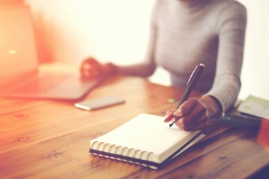 Seçici odak üzerinde el yazısı ile görüntü kırpılmış yaratıcı çalışma işlemi sırasında boş sayfaları Not Defteri'nde bilgi dizüstü kullanarak web sitesi kopyalama afro Amerikan işkadını bulanık 