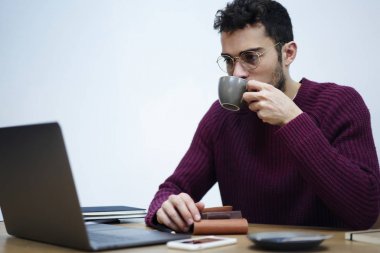 Akıllı öğrenci optik gözlük ofis iç oturan kablosuz internet'e bağlanma dizüstü bilgisayarda çalışırken kahve içme yoğunlaştı. Alan arka plan kopyalama