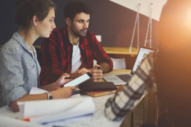 Yaratıcı erkek ve öğrencilerin teamworking modern dizüstü cihaz oturan ve verimli çalışması için dokunmatik yüzey kullanarak beyin fırtınası eğitim sırasında. Genç tasarımcılar Webinar macbook bilgisayarda izliyorum