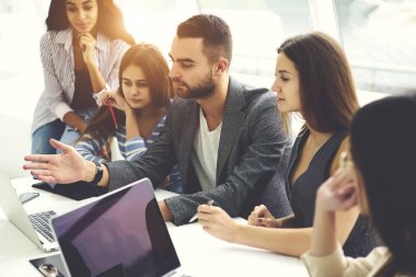 Genç öğrenci Koç açıklama teknolojisiyle, tarassut video üstünde laptop tasarım projesi tanıtımı hakkında fikir paylaşımı meslektaşları hakkında ders sırasında dinlerken çeşitlilik grubu