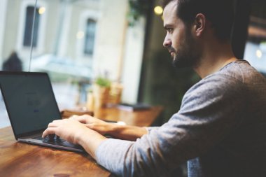 Dalgın görüntü kırpılmış Bu geliştirici reklam metin mesajınız için sahte alanı dizüstü cihaz üzerindeki yeni program yükleme. Erkek metin yazarı kapalı kafeteryada oturan bilgi klavye