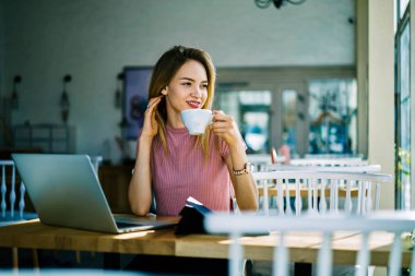 Profesyonel sarışın İdari Yöneticisi üzerinde kahve dinlenme zevk büyüleyici kır kafede iç, gülümseyen iş başlangıç hakkında düşünme, planlama çalışma süreci çay yudumlarken proje