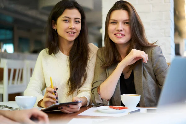 年轻繁荣的女性同事的肖像满意的成果工作和合作的项目 微笑的业务合作伙伴看着相机坐在桌子上的咖啡馆沟通 — 图库照片