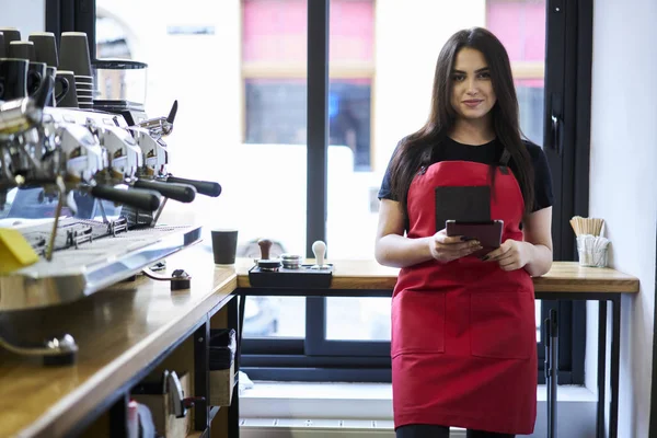 Portrait Charming Waitress Dressed Red Apron Looking Camera Holding Digital — Stok Foto