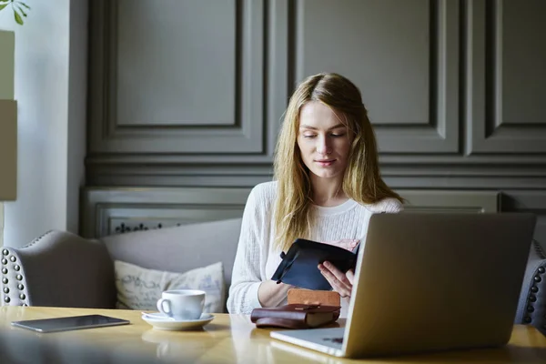 Junge Konzentrierte Studentin Überprüft Informationen Aus Dem Notizblock Während Sie — Stockfoto