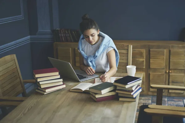 Estudiante Calificada Anotando Algunos Registros Libro Mientras Está Sentado Dispositivo — Foto de Stock