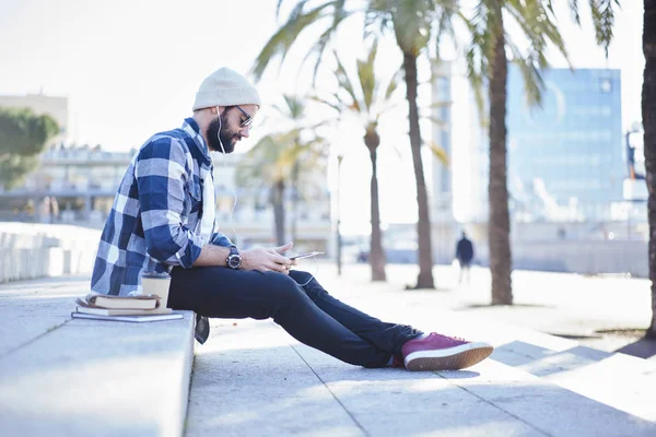 Trendy Dressed Male Hipster Resting Sitting City Square Downtown Listening — Stock Photo, Image