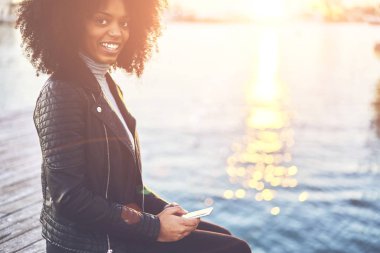 Hippi kız gülümseyerek, yarım uzunluk portre sokulgan yolu ile 4 g için serbest zaman açık havada harcama sırasında bağlı modern cep için komik iletiler gönderilirken kameraya bakarak gündelik kıyafeti giymiş