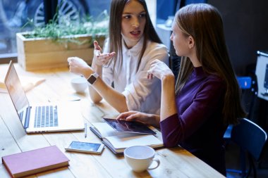 İki yaratıcı genç birbirleriyle iletişim kurmak ilginç sunum web sitelerinde bilgi aramak için eğitim kitapları ve modern Dokunmatik ped ve macbook bilgisayar kullanarak oluşturma hakkında