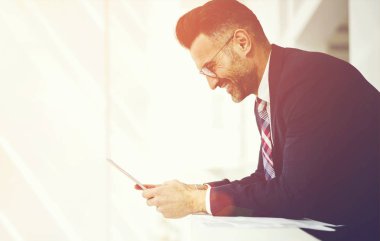 Neşeli erkek girişimci yan görünüm şık takım elbise giymiş bir gözlük alınan değmek geribildirim iyi teklif, icra müdürü ile finansal Haberler memnun gülümseyen ile e-posta kontrol