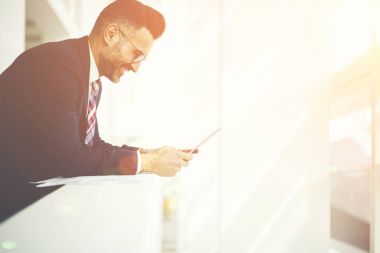 Neşeli erkek girişimci yan görünüm şık takım elbise giymiş bir gözlük alınan değmek geribildirim iyi teklif, icra müdürü ile finansal Haberler memnun gülümseyen ile e-posta kontrol