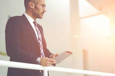 Dalgın şık giyimli erkek girişimci iş gezisi, gurur CEO'su çalışanın online iş denetimi için bilet rezervasyonu için dijital tablet ve wifi bağlantısı kullanarak uygulama touchpad üzerinde kullanarak.