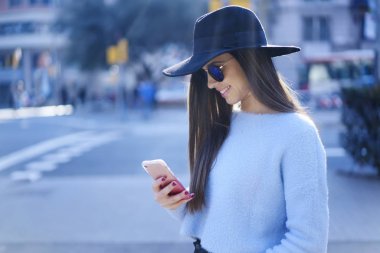 Şirin esmer kadın blogger manifatura iletilere takipçileri şehir sokakları gezinme sırasında kişisel web sitesinde. Genç hippi kız rekreasyon zaman iyi bir ruh hali ve gadge sahip