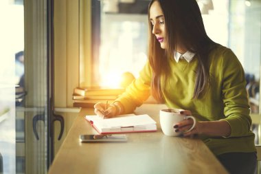 Defter iş kahve, tadını çıkarırken organize çalışma programı yazma dalgın kadın idari işler müdürü konsantre güzel öğrenci kafe iç öğrenme defter rapor yazma