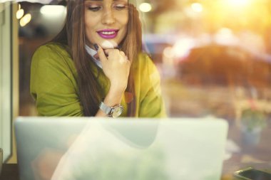 Kafede dizüstü bilgisayar kullanan bilgi ve becerileri geliştirmek için web tasarımcı izlerken webinar gülümseyen ağdan bilgi analiz Finansal Haberler kadın Yöneticisi büyüleyici memnun