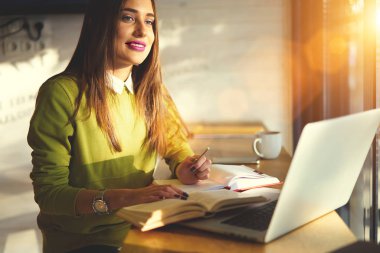 Web tasarım çözümleri kullanarak dizüstü bilgisayar, çekici zeki öğrenci kafe iç ödev hazırlama hakkında düşünme becerilerini geliştirmek bilgi öğrenme esmer kadın Stajyer Büyüleyici