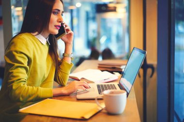 Uzak iş, kafede oturan ciddi telefon konuşmayı çekici kadın kadın girişimci için operatör telefon üzerinden konuşurken Web sitesinde rezervasyon yapma konsantre