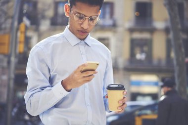 Yakışıklı ciddi erkek gezgin manifatura geribildirim serbest zaman açık havada harcama yaparken cep online forum sonrası için. Modern cihaz ve lezzetli beverag ile dinlenme kendine güvenen hipster adam