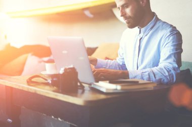 Konsantre yakışıklı blogger tahta masada oturan ve serbest zaman sırasında kafeterya iç lezzetli kahve zevk kuruluş işlemi için Not defterinizde bazı bilgi yazma