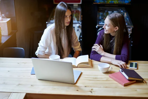 聪明的青少年准备一起为即将到来的考试坐在木桌上 Coworking 空间的培训书籍和使用免费高速4G 互联网连接的现代笔记本电脑 — 图库照片