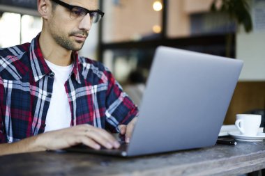 Genç erkek programcı serbest, yayın pazarlama projesinin web pag için profesyonel metin yazarı klavye metin üzerinde çalışan dizüstü kodlama uygulaması yazarak Eyewear konsantre