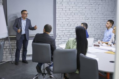 Deneyimli lider kurulu duran ve şık ofis iç iş brifing sırasında yetenekli kadın ve erkek meslektaşları için yeni çalışma planı açıklayan şirketin. Reklam alanı alay