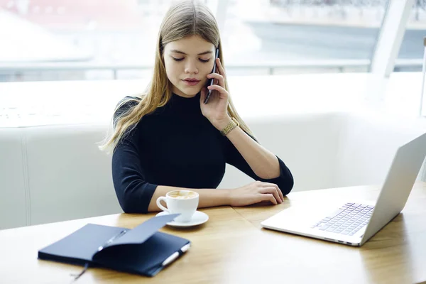 Mujer Hermosa Ocupada Hablando Celular Digital Mientras Está Sentada Computadora —  Fotos de Stock