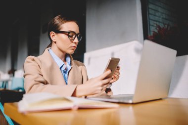 Modern teknoloji, gazeteci dizüstü bilgisayar kullanan uzak iş cep gelir mesaj okuma Eyewear kullanarak iş planı yapma kadın girişimci telefon numarası çevirmeden konsantre
