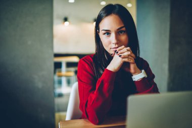 Genç kadın kamera bilgi arama ve bankacılık için dizüstü bilgisayar kullanan bakarak uzak iş güncelleştirme multimedya içerik ağlarında yetenekli kadın Freelancer portre konsantre