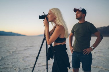 Erkek ve kadın gezginler sonra Death Valley'de blogcular birlikte sefer yiyorsunuz Badwater kuru göl manzara çekim üzerinde çalışma sırasında akşam alacakaranlık doğa çevre resim çekmek