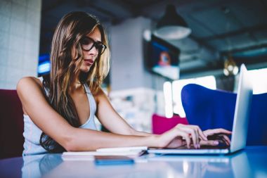 Uzak iş dizüstü metin Web sitesinde yayınlanmak araştırma online online kurslar kafede serbest zaman sırasında eğitim yapma ciddi hippi kız yazarak konsantre yetenekli kadın metin yazarı