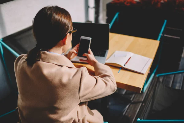 Achteraanzicht Van Vrouwelijke Journalist Telefoon Multimedia Bestanden Synchroniseren Met Netbook — Stockfoto