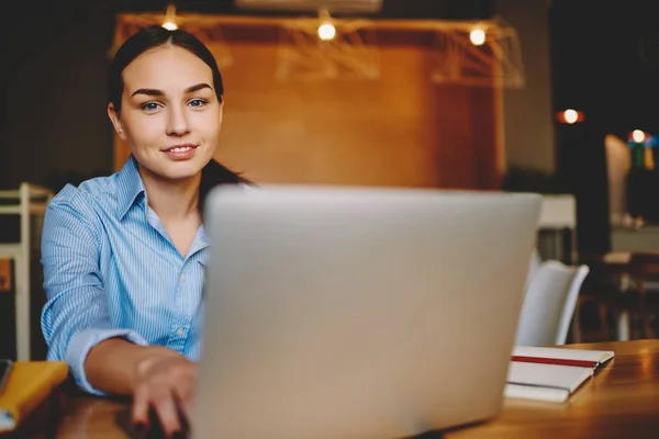 カフェに座っているネットブックでオンライン調査のラップトップ コンピューターを使用してリモート ジョブをやってかなりビジネスの女性の肖像画は Web ページ上の予約を行うカメラを見て魅力的な女性経営者閲覧 — ストック写真