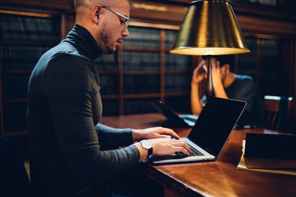 Junger Männlicher Wissenschaftler Brille Tippt Laptop Literatur Aus Dem Archiv — Stockfoto