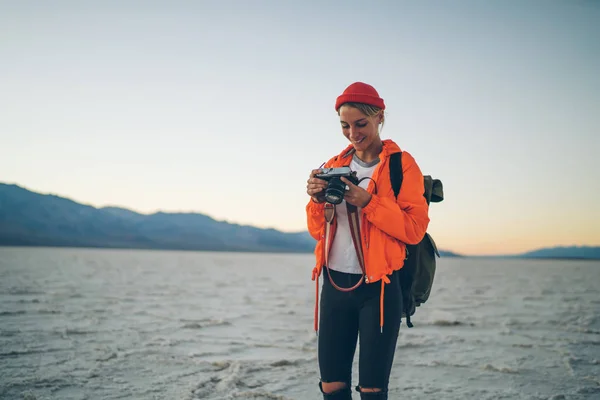 微笑的女孩观看照片在恶水国家公园的野外探险 职业女性摄影师检查设置死亡谷旅行中的设备工作 — 图库照片
