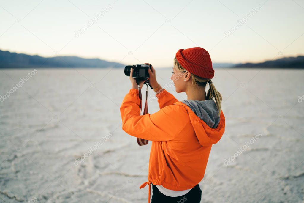 Young woman exploring natural landmark of california taking picture of natural landscape, female photographer working during hiking traveling in Death valley enjoying scenic desolate environment   
