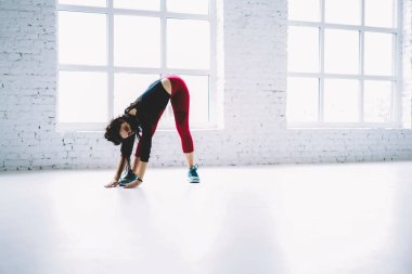 Genç sporcumuz aktif giyim eğitim salonunda pilates, genç kız bantlama ve tutulması uygun egzersiz ve sağlıklı yaşam beyaz iç Studio'da başlamadan önce egzersiz sırasında kas germe