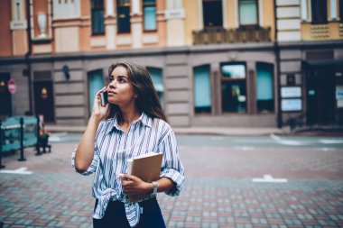 Açık havada vakit dijital Smartphone'da iletişim kurulurken ararken el kitaplarında düşünceli şirin öğrenciyle. Hippi kız toplantı ayakta Caddesi üzerinde düzenleme telefon sohbet