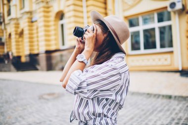 Şık kadın seyahat tatil gezi kentsel ayarları sokakta duran fotoğrafını çekmek hobi harcama. Profesyonel fotoğrafçı Vintage kameralar şehir mimarisi resmini yapmak için kullanma