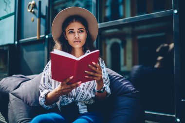 İlginç romanın arsa üzerinde baş düşünme üzerine şapkalı düşünceli çekici yetenekli hippi kız kırmızı edebiyat book.pondering öğrenci üzerinde favori bestseller zevk coworking, kabarık dinlenme okuyun