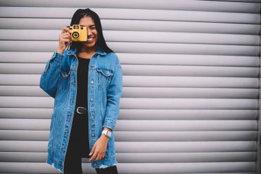 Trendy denim ceket ayakta modern sarı makinesinde fotoğraf koleksiyonu için resim yapma kopyalama alanı alanı yakınındaki promosyon gri arka plan üzerinde şık afro Amerikan modeli giymiş