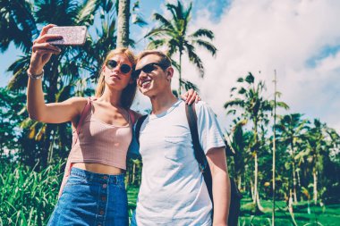 Hippi kız alma resim sevgilisi ile birlikte seyahat gülümseyen yolculuk macera tropik adada zevk smartphone kamera selfie yaparken poz Romantik Çift