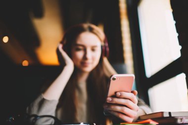 Seçici odak modern smartphone Ücretsiz online müzik dinleme için yüksek hızlı 4 g internet bağlantısı bağlanma tutan el üzerinde. Kýsa mesaj veya reklam içeriği için arka plan bulanık